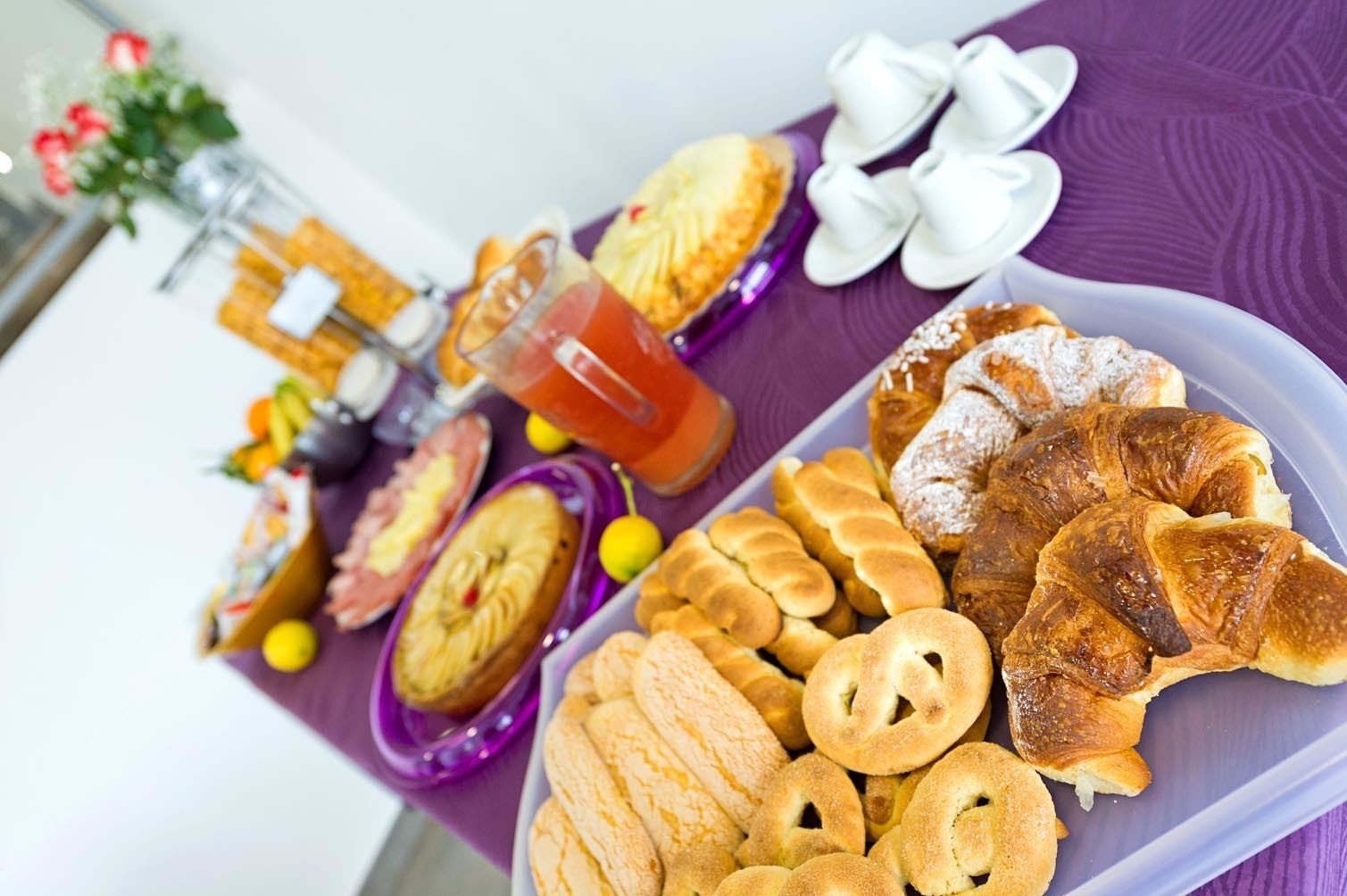 A tray of assorted pastries and a glass of iced tea on a table.