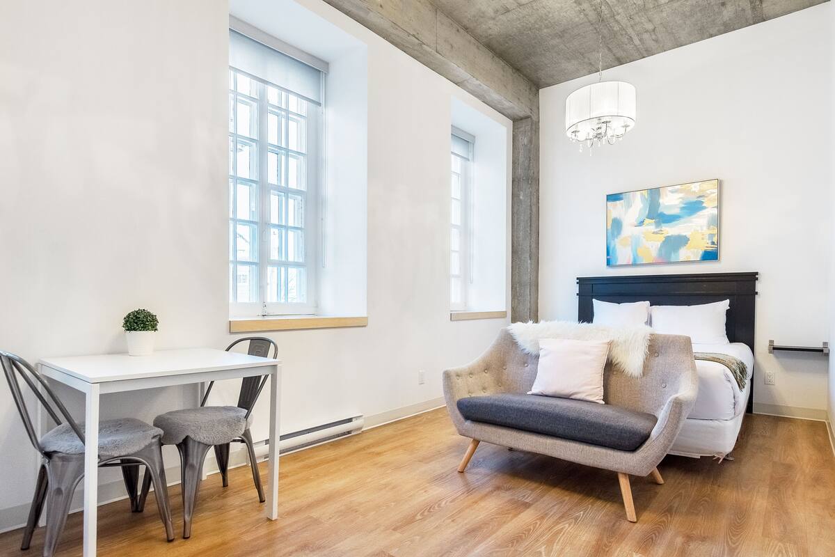 A modern bedroom with a bed, a desk, and a chair.