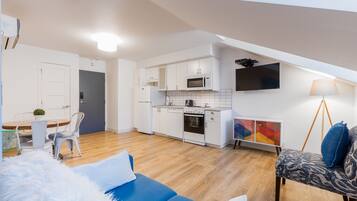 Een modern appartement met keuken, eethoek en woonkamer.