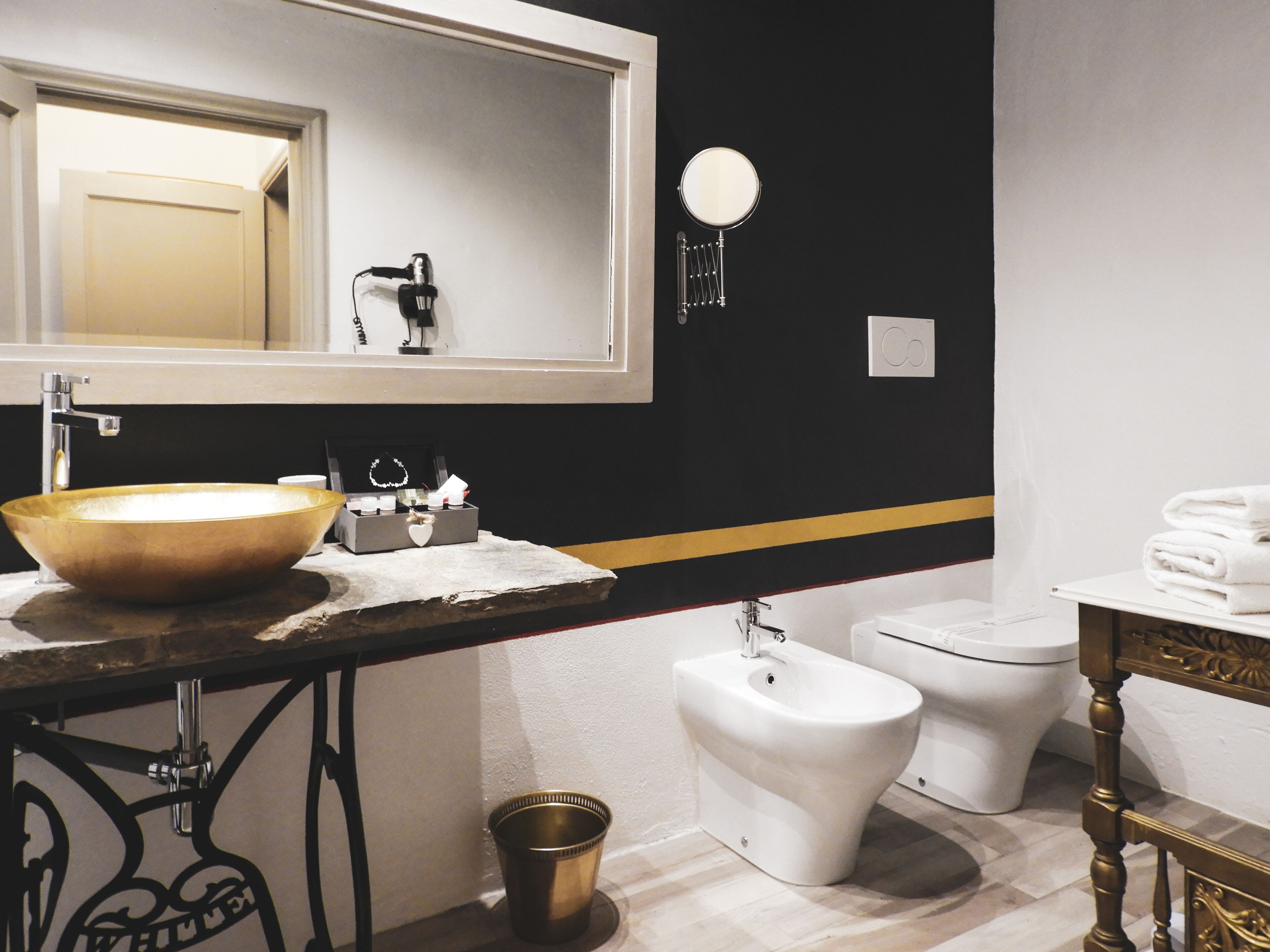 Un baño moderno con un lavamanos grande tipo lavabo, un bidé, un inodoro y un mueble de tocador con espejo.