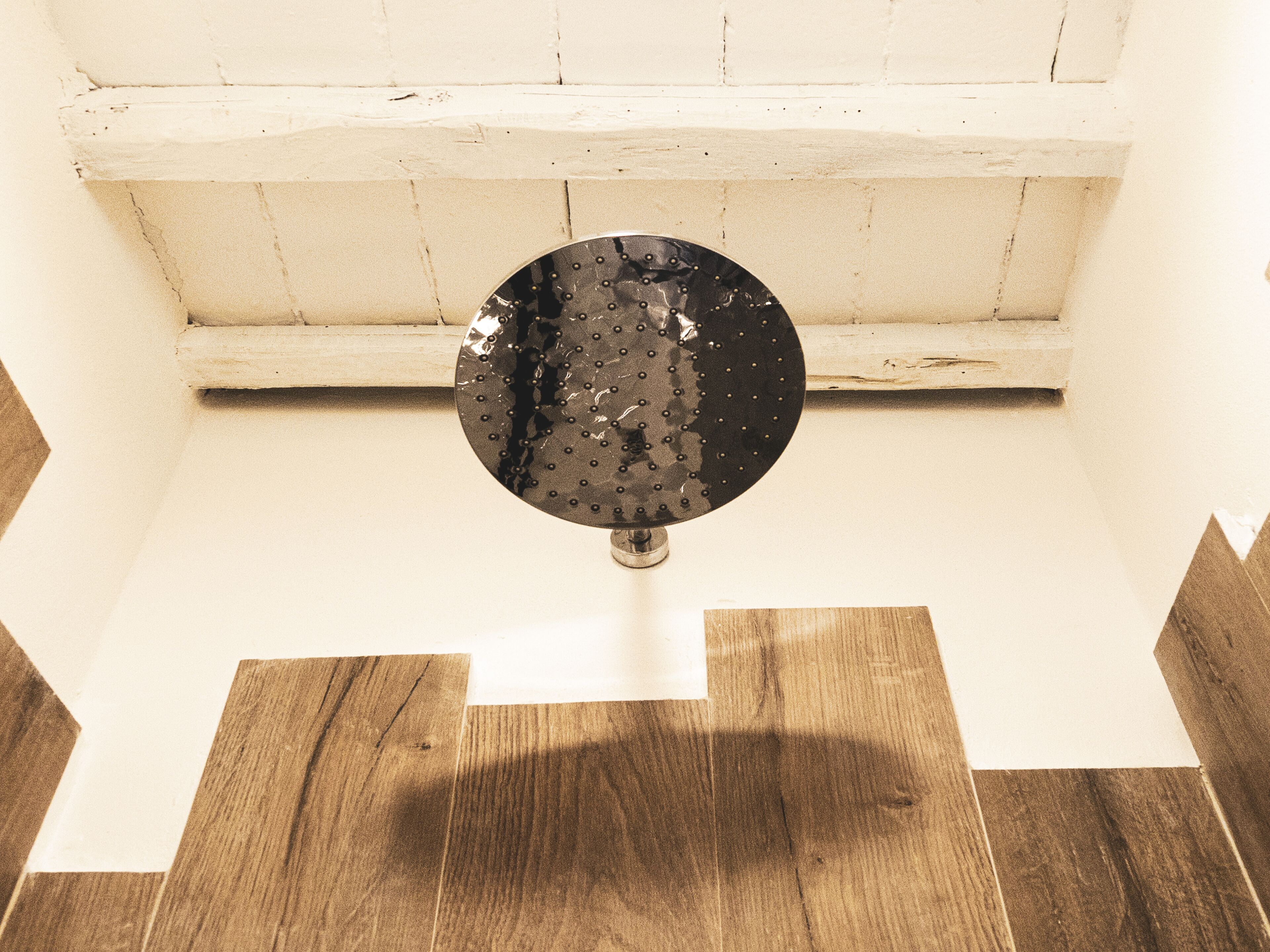 A circular object on a white wall with a wooden floor.