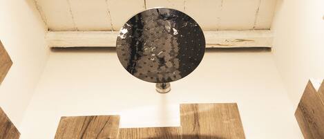 A circular object on a white wall with a wooden floor.