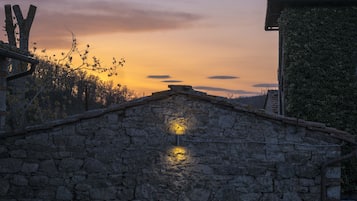 A stone building with a stone wall and a small light fixture.