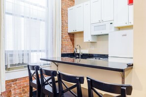 Compact kitchen with central island, sink, and microwave, offering a casual dining or working space with a view.