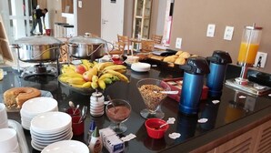 Un buffet proposant une variété d’aliments, notamment des fruits, des céréales et des boissons.