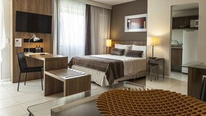 Une chambre d’hôtel moderne équipée d’un lit, d’un bureau, d’une chaise et d’une table à manger en verre.