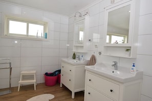 A bathroom with white tiled walls, two sinks, a large mirror, and a window. - Solferie Holiday Home Bordalssvingen (Kristiansand)