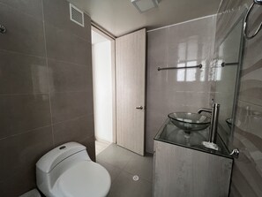 A modern bathroom with a toilet, glass sink, and a shower area. - Hotel Bestmark Platinum (Bogotá)