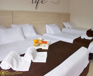 A hotel room with two beds, white bedding, a tray with breakfast items, and rolled towels. - Hotel Bestmark Platinum (Bogotá)