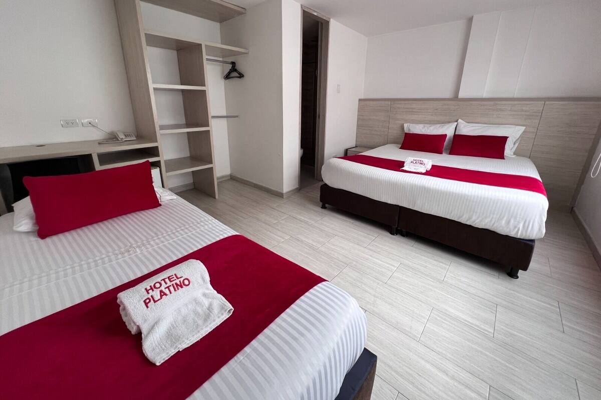 Ein Hotelzimmer mit zwei Betten, einem Kleiderschrank und einem Schreibtisch.