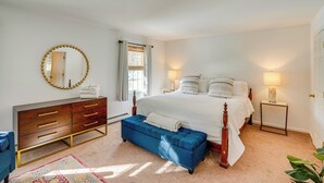 Ein Schlafzimmer mit Bett, Schminktisch, Spiegel und Nachttisch.
