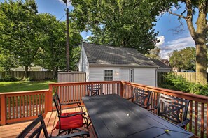 A deck with a table and chairs, surrounded by a wooden railing, with a house in the background. - Indianapolis Vacation Rental - Walk to the IMS! (Indianapolis)