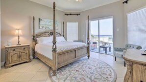 Quarto com uma cama de dossel, mesa de cabeceira, abajur, janela grande e vista para o exterior.