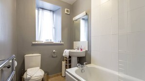 Un baño con inodoro, lavamanos y bañera.