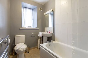 A bathroom with a toilet, sink, and bathtub.