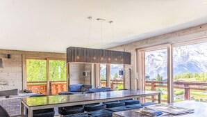 Una cocina moderna con una isla grande, detalles de madera y vistas a las montañas.