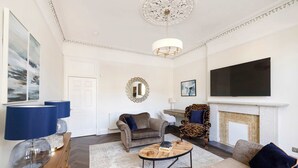 Una sala de estar con chimenea, televisión y un sofá.