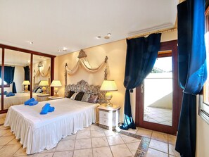 Relax in a spacious room with a classic four-poster bed, ornate headboard, and matching lamps.