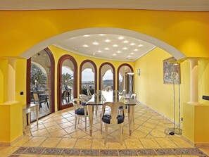 Enjoy meals in style with a large dining table and city views through arched windows.