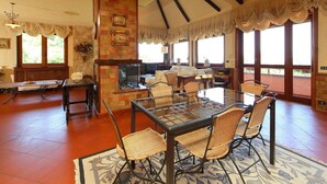A spacious living room with a fireplace, large windows, and a high ceiling with exposed beams. - Private Villa with A/C, hot tub, private pool, WIFI, TV, patio, pets allowed, panoramic view (Monte Compatri)