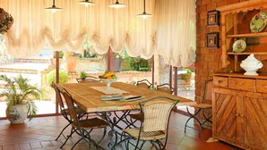 A dining area with a wooden table, wicker chairs, and hanging pendant lights. - Private Villa with A/C, hot tub, private pool, WIFI, TV, patio, pets allowed, panoramic view (Monte Compatri)