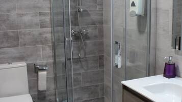 Habitación cuádruple | Baño | Artículos de higiene personal gratuitos, secador de pelo y toallas