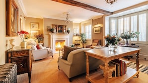 A cozy living room with a fireplace, comfortable seating, and a dining table.