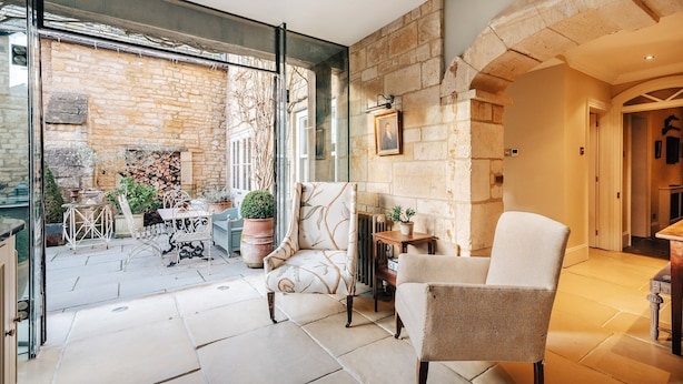 A spacious room with a stone fireplace, a comfortable armchair, and a dining area with a table and chairs.