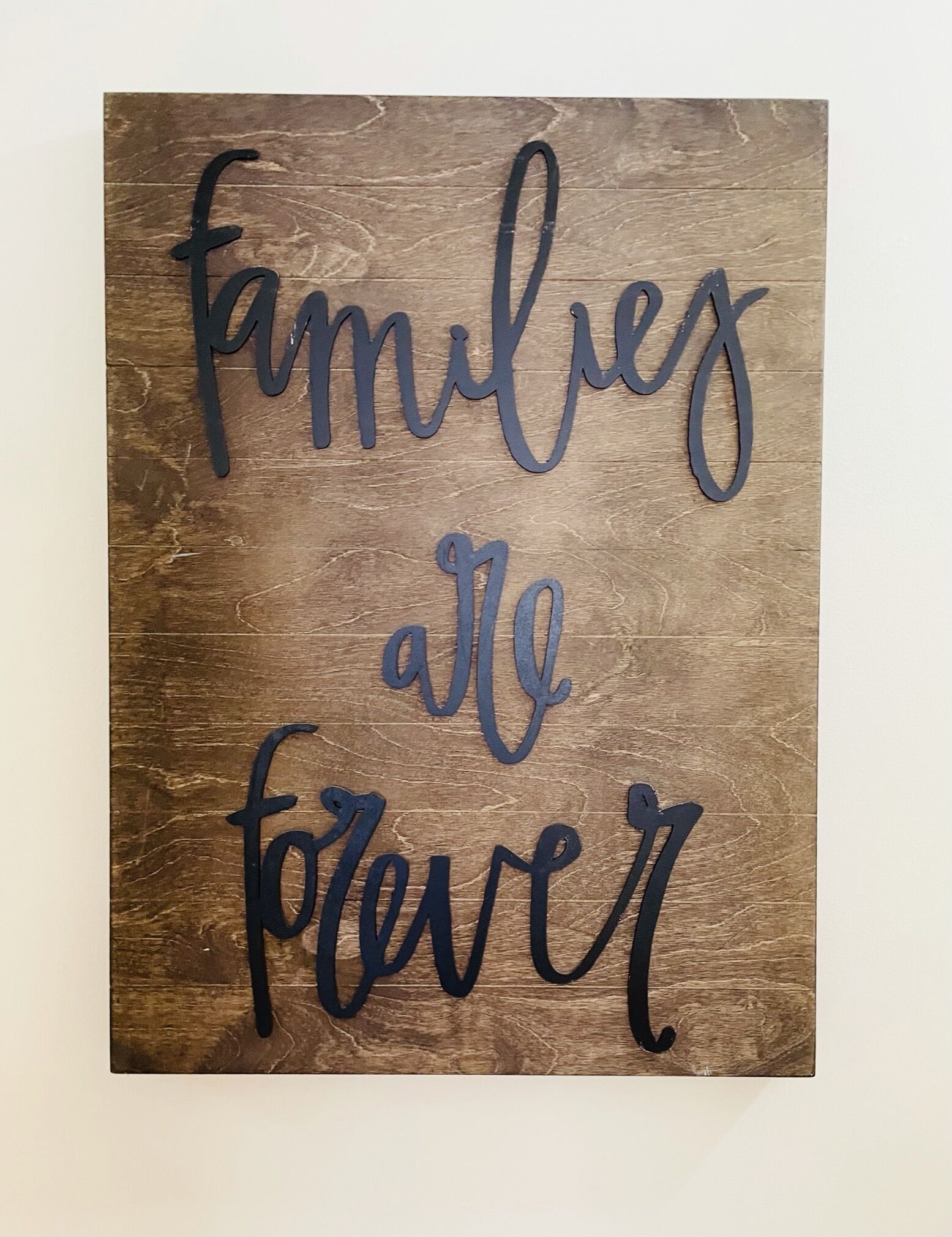 A wooden sign with the phrase "families are forever" written in cursive.