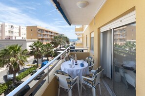 A balcony with a table set for two, chairs, a bottle, and a cup. - RIVER - Apartment with sea views Free WiFi (Daimús)