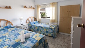 A bedroom with two beds, a nightstand, a dresser, and a window with curtains. - RIVER  - Apartment with sea views Free WiFi (Daimús)