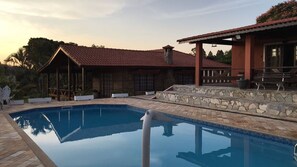 Una piscina con baldosas de piedra y cubierta de madera.