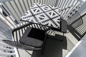 Relax in an outdoor space with a geometric-patterned table and two comfortable chairs.