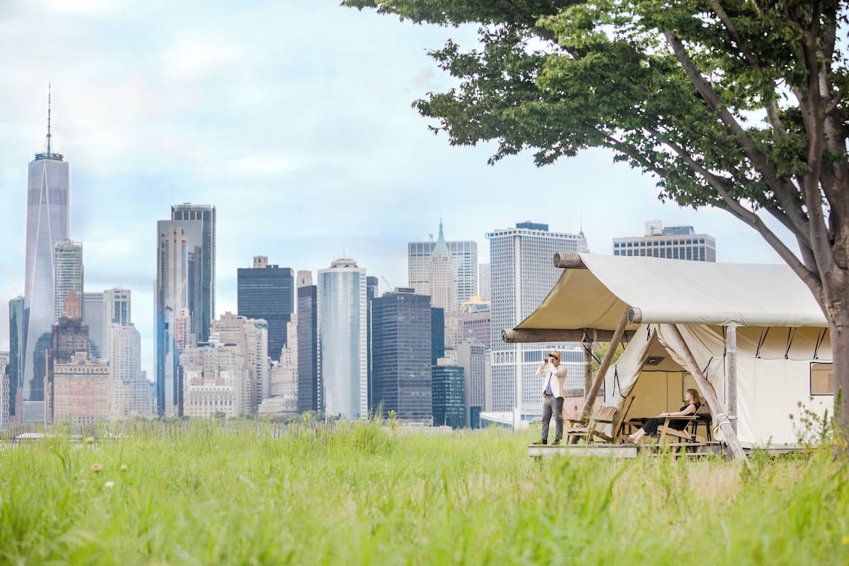 Un área con carpas y un horizonte urbano al fondo.