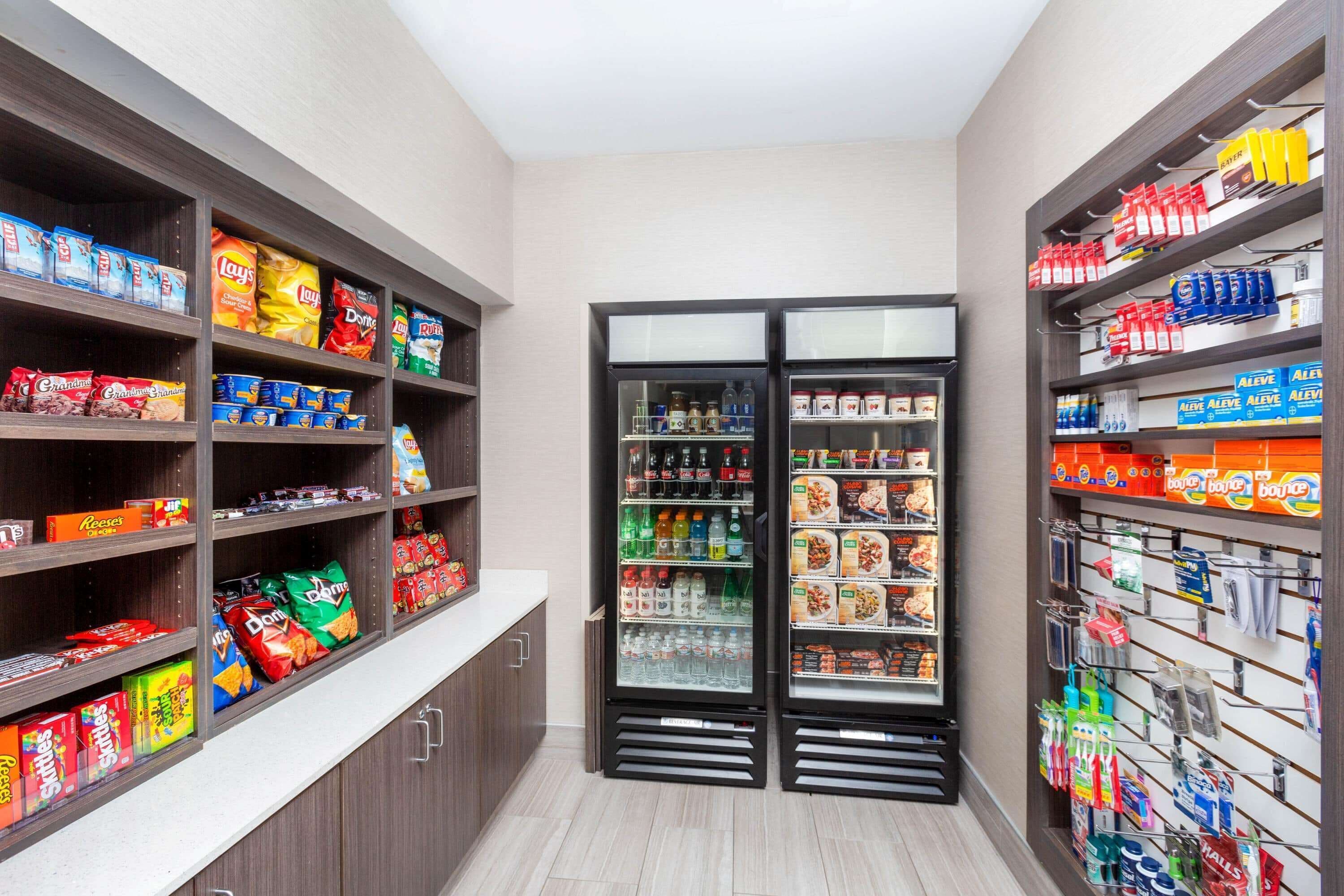 A grocery store with shelves stocked with snacks, beverages, and household items.