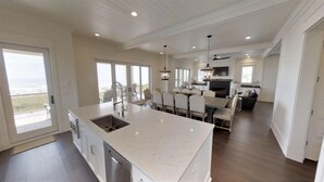 A spacious kitchen with a large island, modern appliances, and a view to the outside.