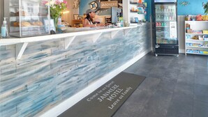 Zona de recepción de un hotel con una vitrina de cristal, un mostrador con el letrero
