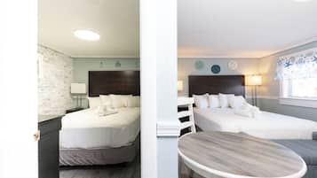 Habitación de hotel con dos camas, una mesita y decoración náutica.