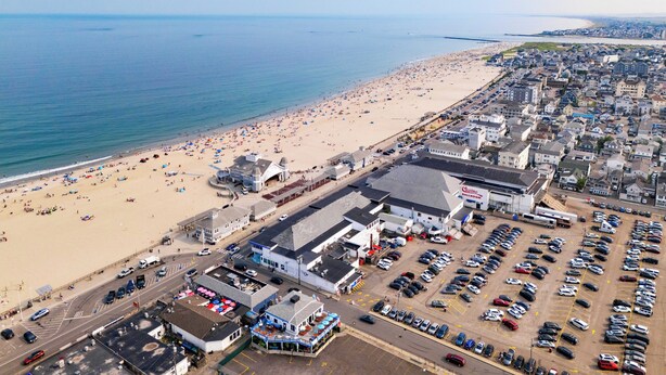 Vista aérea de un pueblo costero con playa, un casino y un estacionamiento.