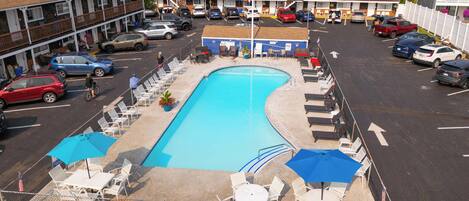 Una piscina al aire libre de temporada, sombrillas