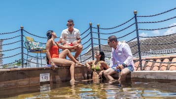 Una piscina al aire libre, sillones reclinables de piscina