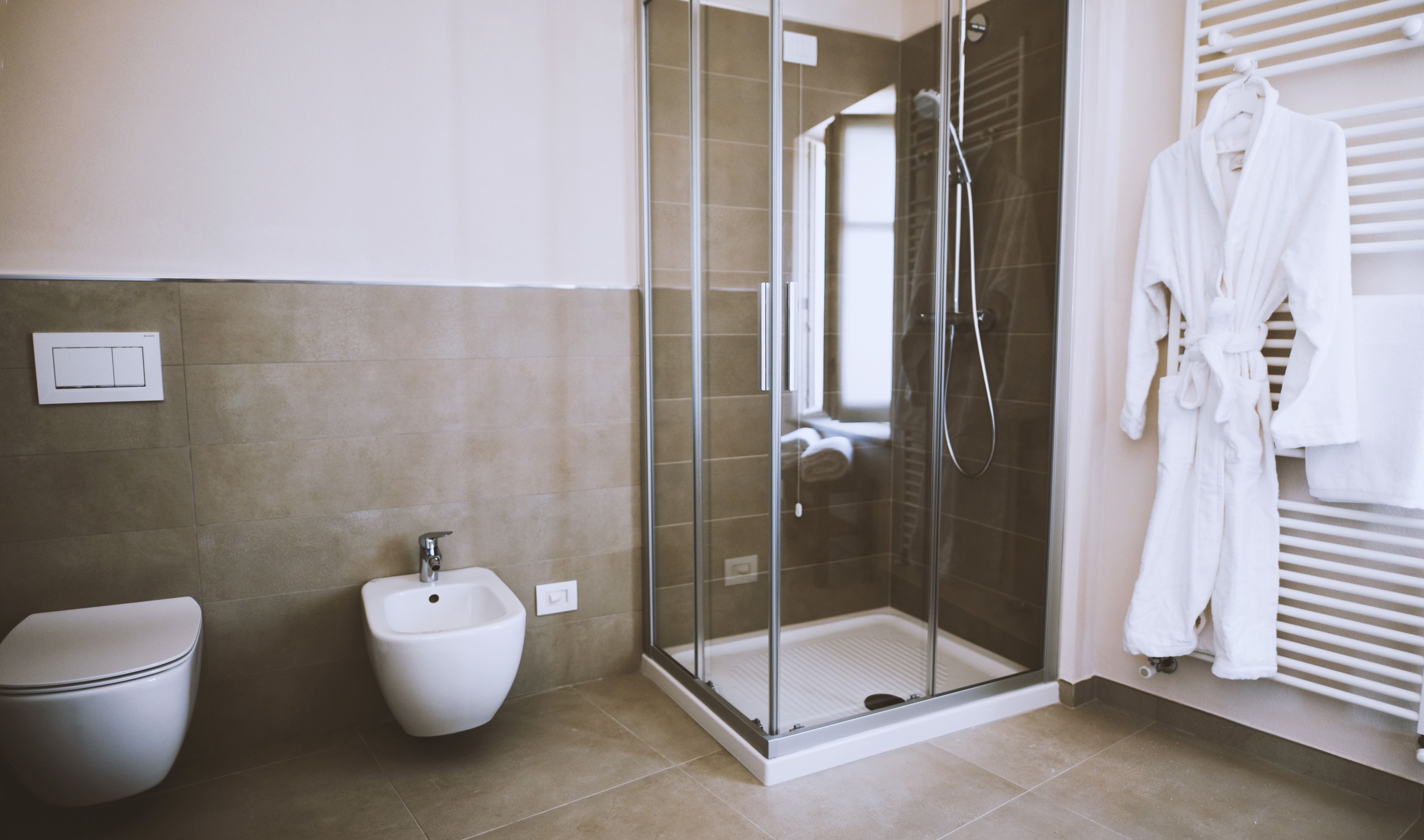 Un baño moderno con ducha de vidrio, un bidé y un inodoro.
