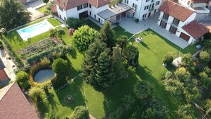 An aerial view of a residential area with multiple houses, a swimming pool, and well-maintained gardens. - Moonfrà (Antignano)