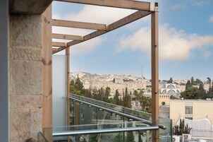 Vista desde un balcón con baranda de metal, que domina un paisaje urbano con edificios históricos y una mezquita.