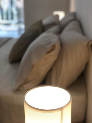 A room with a bed, a lamp, and a window. - Syds Guesthouse I (Praia)