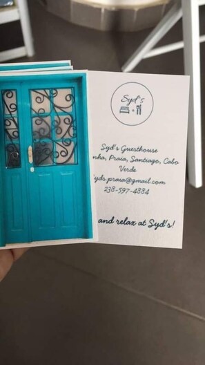 A business card for Syd's Guesthouse, including the address and contact information. - Syds Guesthouse I (Praia)