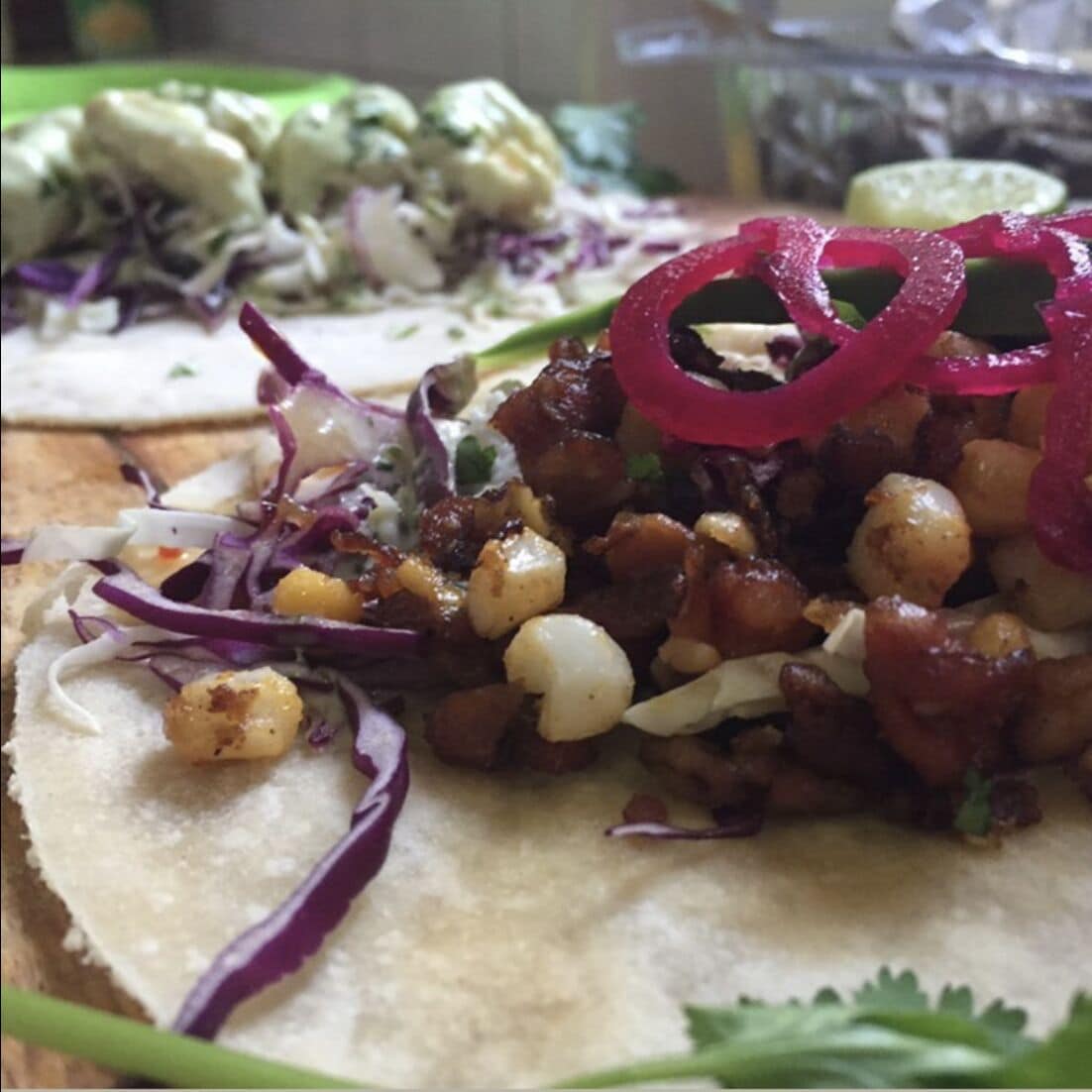 Un plato de tacos con varios ingredientes, como cebolla, cilantro y posiblemente carne.
