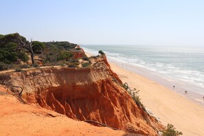 A coastal landscape with a sandy beach, cliffs, and sparse vegetation. - Luxury Villa with swimming pool (Falésia)