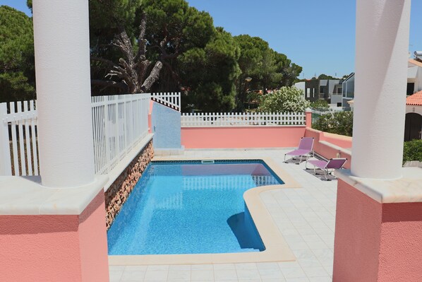 A swimming pool with a white fence and chairs around it. - Luxury Villa with swimming pool (Falésia)