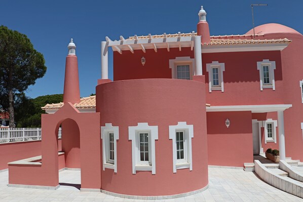 A pink building with white trim, a tiled roof, and a white fence. - Luxury Villa with swimming pool (Falésia)